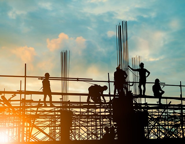 Silhouette of engineer and construction team working safely on scaffolding on high rise building. over blurred background sunset pastel for industry background with Light fair